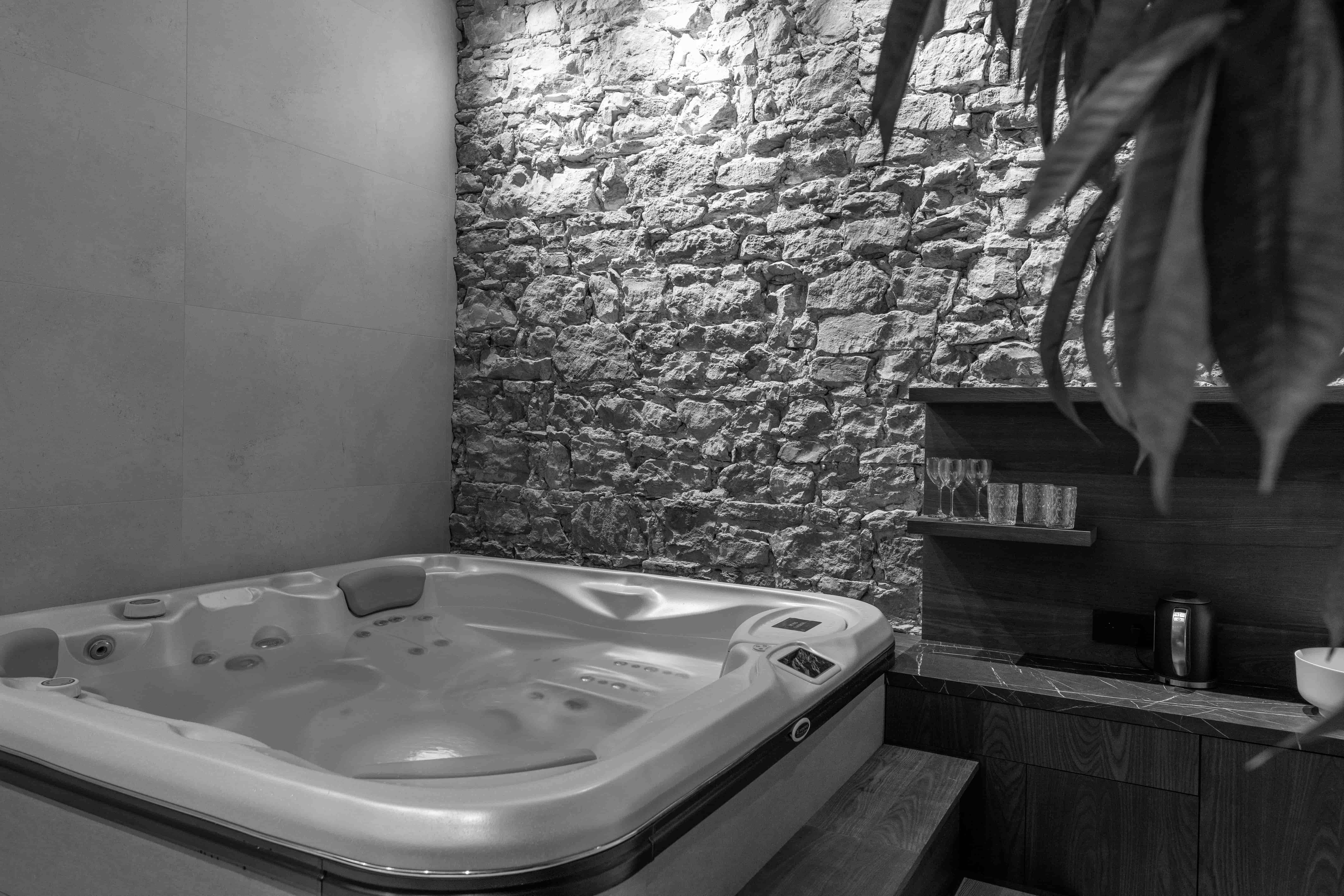 Jacuzzi 5 personnes avec mur en pierres et tisanerie